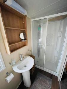 a small bathroom with a sink and a shower at Caravan Retreats in Conwy