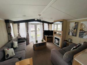 a living room with two couches and a tv at Caravan Retreats in Conwy