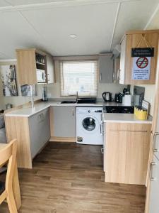 uma pequena cozinha com fogão e máquina de lavar e secar roupa em Caravan Retreats em Conwy