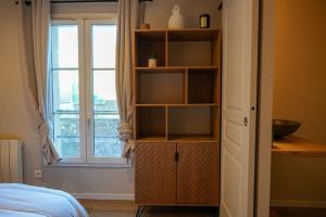 estante de libros en un dormitorio con ventana en Appartement Saint-Valery, en Saint-Valery-sur-Somme