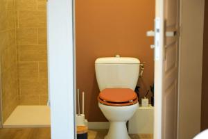 La salle de bains est pourvue de toilettes et d'un siège en bois. dans l'établissement Appartement Saint-Valery, à Saint-Valery-sur-Somme