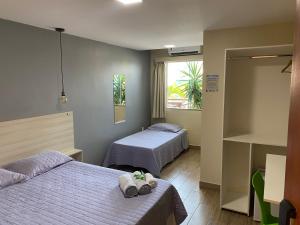 a hotel room with two beds and a window at Pousada Mirante da Prainha in Arraial do Cabo
