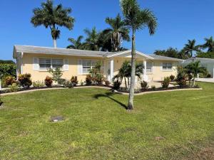 a yellow house with palm trees in a yard at Modern Apartment - 4 of 4 in Punta Gorda