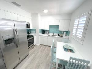 a kitchen with a refrigerator and a table with chairs at Modern Apartment - 4 of 4 in Punta Gorda