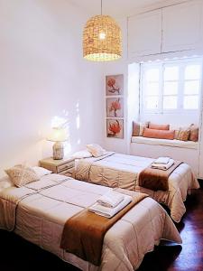 um quarto com 3 camas e um lustre em CASA ARISTIDES em Mendoza
