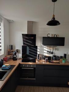 a kitchen with black cabinets and a stove top oven at Maison au calme proche centre ville in Le Mans