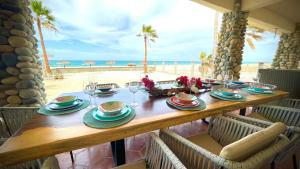 una mesa con platos y copas de vino en la playa en CASA SUEÑO AZUL, en Buenavista