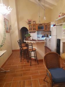 eine Küche mit Stühlen, einem Tisch und einer Theke in der Unterkunft Alexander's Apartment Carriacou in Carriacou