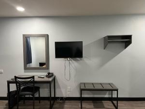 a room with a table and a tv on a wall at Travel Inn Gilroy in Gilroy