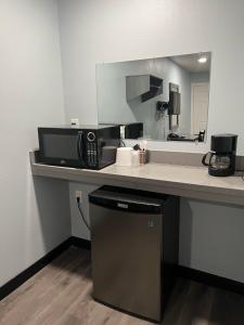 La salle de bains est pourvue d'un comptoir avec un four micro-ondes et un miroir. dans l'établissement Travel Inn Gilroy, à Gilroy