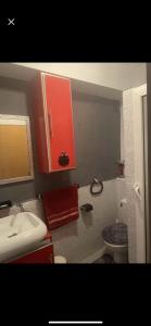 baño con lavabo y armario rojo en شقة مفرشة, 