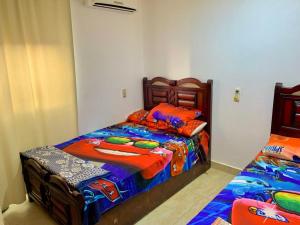 1 dormitorio con 2 camas individuales y ropa de cama colorida en Marina Wadi Degla Resort Families Only en Ain Sokhna