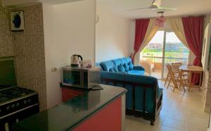 Marina Wadi Degla Resort Families Only في العين السخنة: مطبخ وغرفة معيشة مع أريكة وطاولة