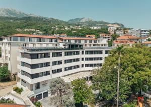 an apartment building in a city with mountains in the background at HOTEL TALIA in Topla