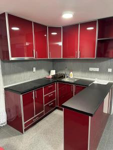 a kitchen with red cabinets and a black counter top at ANGELIKATOS in Golubac