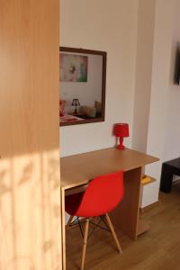 a red chair sitting next to a desk with a red lamp at Apartments Baja in Ulcinj