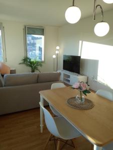 ein Wohnzimmer mit einem Tisch und einem Sofa in der Unterkunft Espectacular apartamento de alquiler en Santa Coloma Barcelona in Santa Coloma de Gramanet