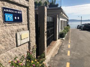 a sign on the side of a building with a parking garage at Airiños do Mar in Areas