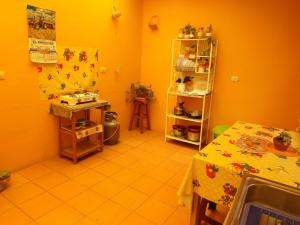 cocina con paredes de color naranja, mesa, mesa y estantería en La Casa del Manzano, en Puno