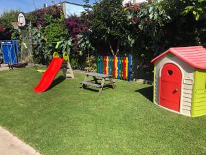 a playground with a slide and a play house at Airiños do Mar in Areas