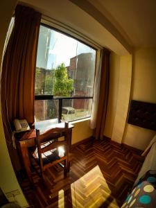 a room with a window and a chair and a table at Hotel Casa Santa Beatriz in Cusco