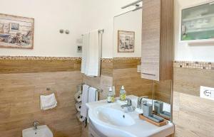 ein weißes Badezimmer mit einem Waschbecken und einem Spiegel in der Unterkunft Sardinia SeaBreeze Villa IUN R2178 in Castelsardo