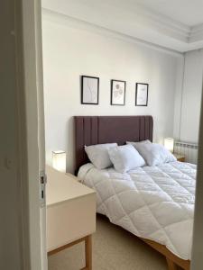 a bedroom with a large bed with three pictures on the wall at Spacieux, chaleureux et élégant in Nabeul