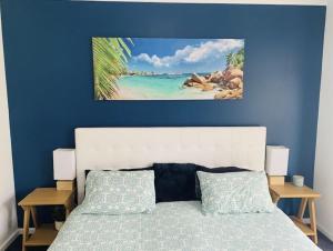 a bedroom with a bed with a blue wall at Sea & Vines in McLaren Flat
