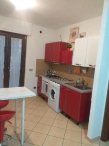 een keuken met rode kasten en een wasmachine bij Hillary E Vale Room in Rome
