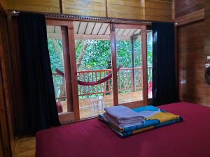 a bed in front of a window in a room at Santi Garden Bungalows in Iboih