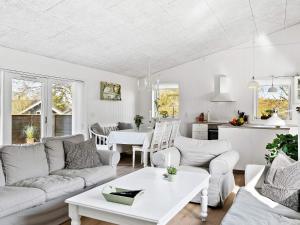 uma sala de estar com mobiliário branco e uma cozinha em Holiday home Slagelse XVIII em Slagelse