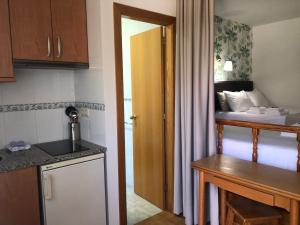 a room with a kitchen and a bedroom with a bed at Airiños do Mar in Areas
