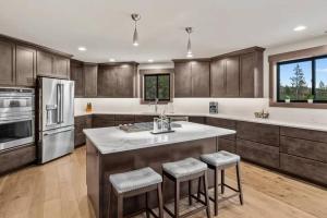 a kitchen with wooden cabinets and a kitchen island with stools at Summit House in Cle Elum