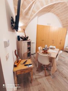 un comedor con mesa y sillas y una habitación con techo en Affittacamere Sapore di Mare, en Talsano