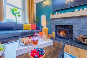 a living room with a table with food and a fireplace at Snowdon House, 8 bedrooms, sleep 16, close to Blackrock Sand in Porthmadog