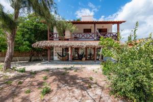 a house with a large porch in front of it at Vila Viva in Barra Grande