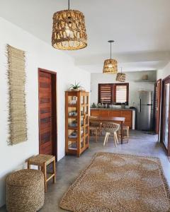 a living room with a table and a kitchen at Vila Viva in Barra Grande