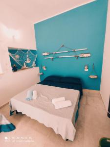 Habitación con cama con pared azul en Affittacamere Sapore di Mare, en Talsano