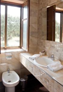 a bathroom with a sink and a toilet and a mirror at Hotel La Rad in Galindo y Perahuy