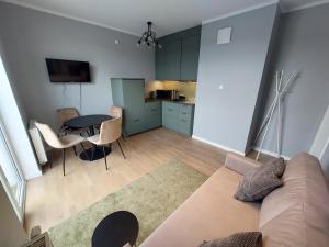 a living room with a couch and a table and a kitchen at Apartament w Gdańsku in Gdańsk