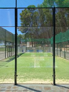 una vista de una pista de tenis desde detrás de una valla en Casa Montelucía en Montecorto
