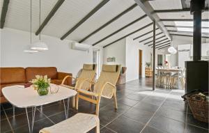uma sala de estar com mesa e cadeiras em Strandbo em Thyholm