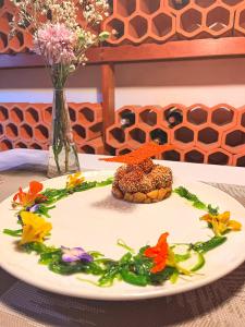 een bord eten op een tafel met bloemen bij Hotel rural casona Santo Domingo in Güimar