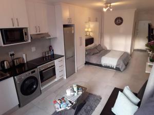 a small living room with a bed and a kitchen at 36 HydePark Apartments in Cape Town +1 photo