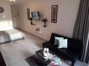 a living room with a couch and a bed at 36 HydePark Apartments in Cape Town