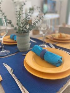 a table with orange plates and blue napkins on it at Apartamento Flori, con terraza y a 300 m de la playa en Suances in Suances