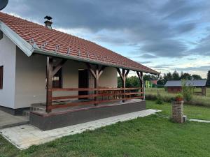 a small white house with a porch and a fence at Mila Vila, Fruška Gora in Irig