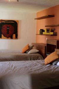 - une chambre avec 2 lits et un tableau mural dans l'établissement Hermosa Casa en Club de Golf San Miguel de Allende, à San Miguel de Allende