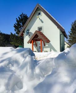 a pile of snow in front of a house at Holiday Home Ljuban in Risovac