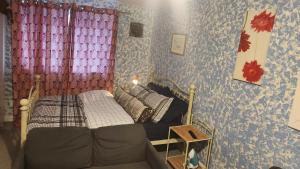 a small bedroom with a bed and a couch at Moris Lodge in Hither Green